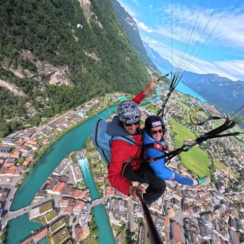 A tandem pair flying above the town and the lake