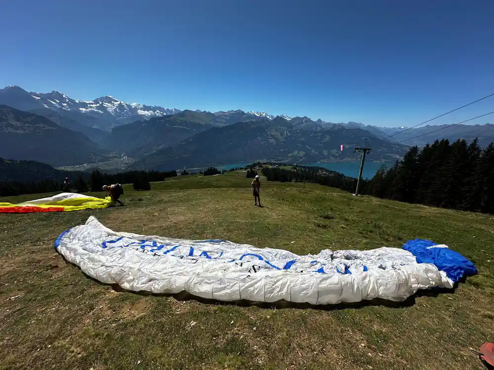 A canopy laid out on the launch meadow above the lake