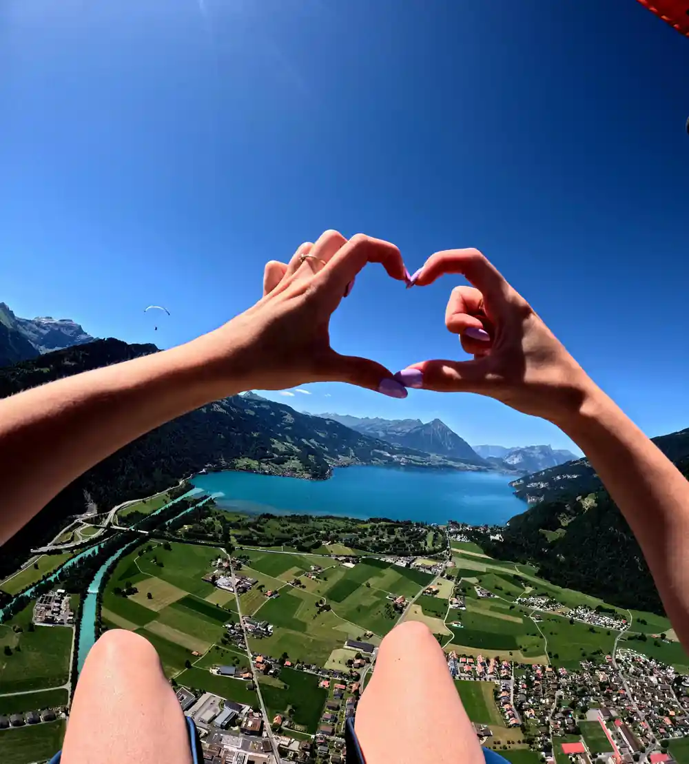 Hands framing the lake and the valley below