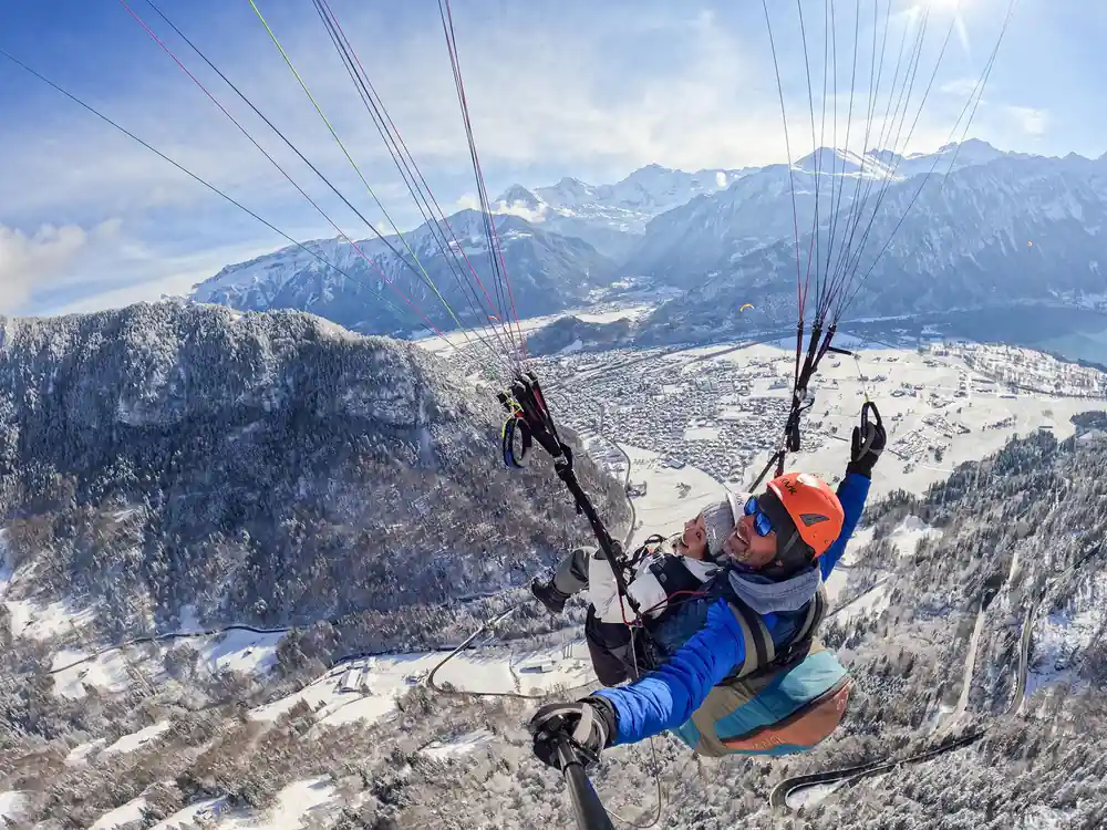 A tandem over the snow-covered valley floor
