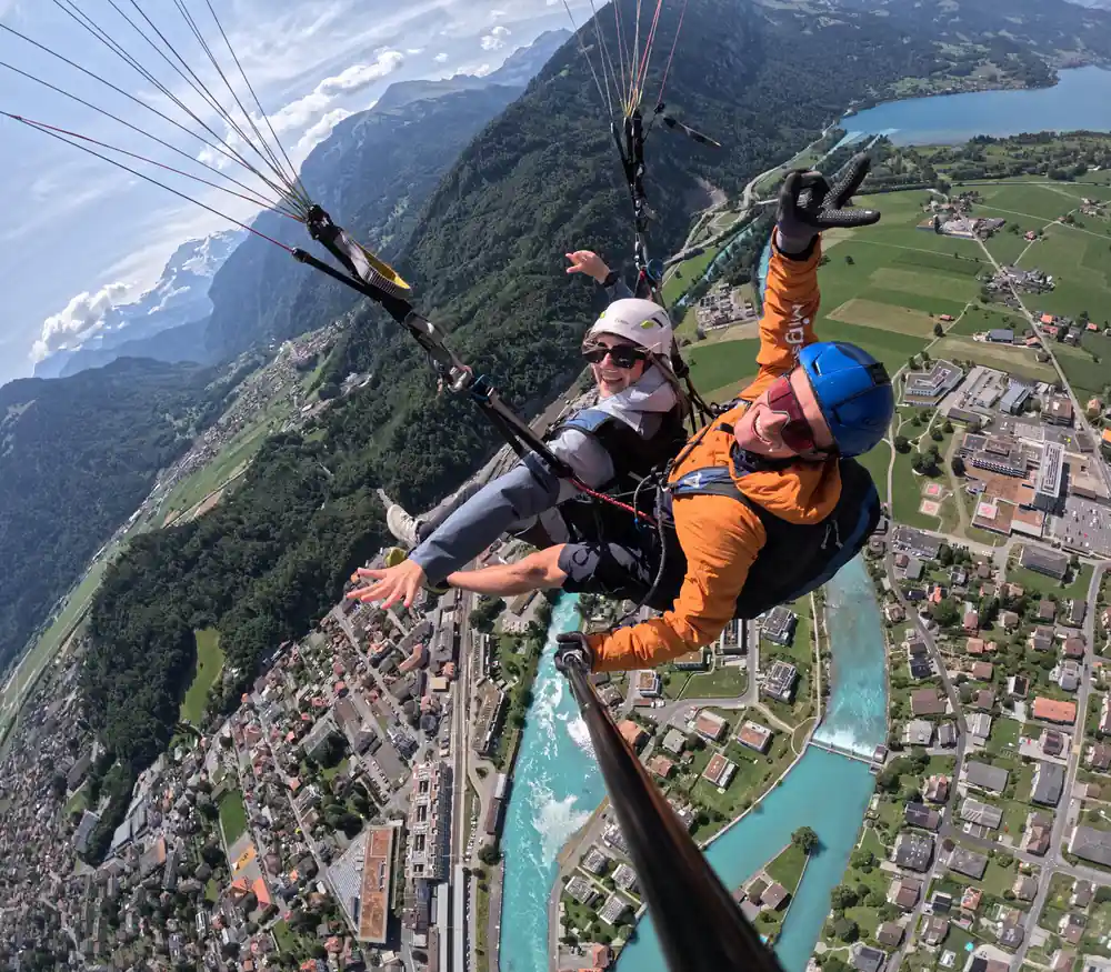 A tandem over the town with the peaks beyond