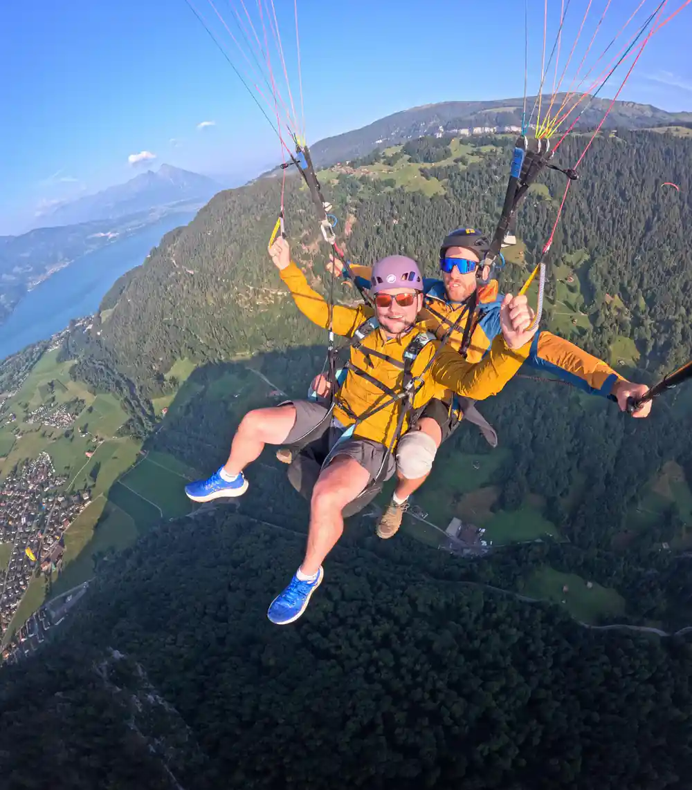 A tandem above the trees with the peaks beyond