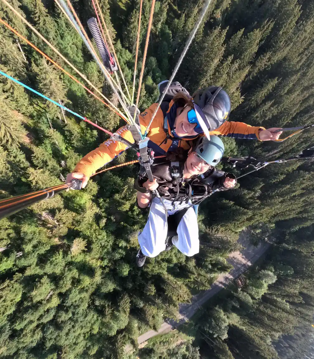 A tandem turning above the forested slope